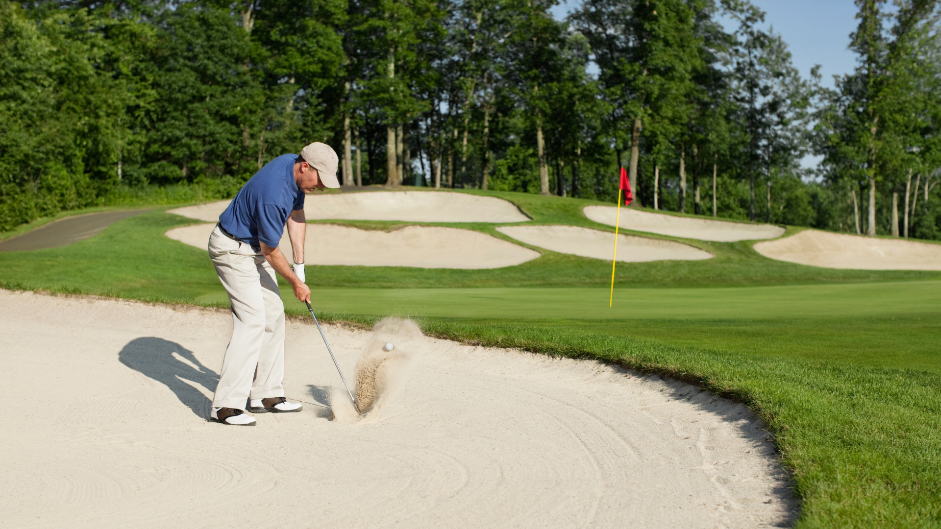 Golfer hitting a ball out of the bunker